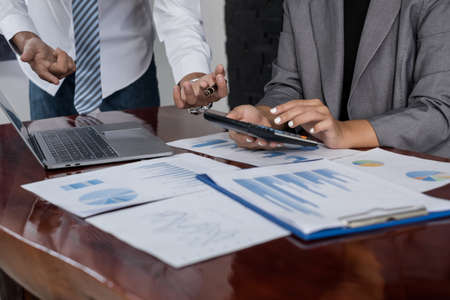 Two business leaders talk about charts, financial graphs showing results are analyzing and calculating planning strategies, business success building processes.の写真素材