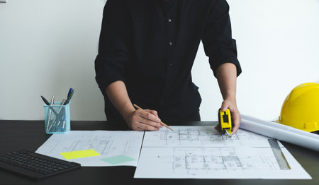 Architects or engineers working construction and drawing construction plans, printing, writing on-site construction sites. Home design concept.の写真素材