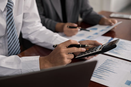 Two business leaders talk about charts, financial graphs showing results are analyzing and calculating planning strategies, business success building processes.の写真素材