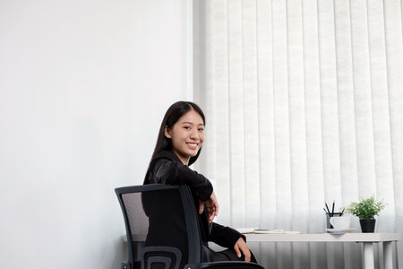 Asian businesswomen sit at their desks and calculate financial graphs showing results about their investments, plan a successful business growth process in the office.の写真素材