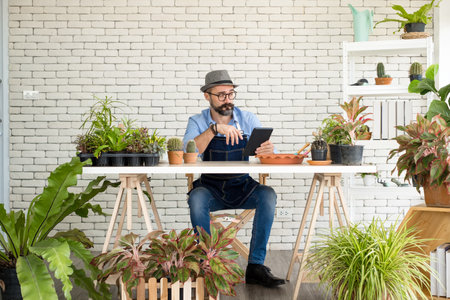 An elderly man handsome with have mustache wearing glasses is happy with tree care. is a hobby of gardening at home, living happily after retirement. Concepts nature and environment.の写真素材