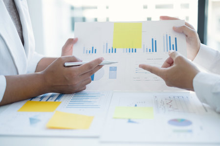 Two business leaders talk about charts, financial graphs showing results are analyzing and calculating planning strategies, business success building processes.の写真素材