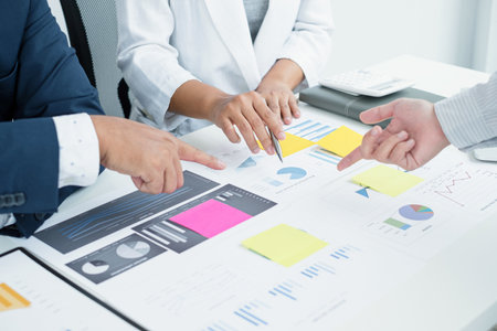 Three business leaders talk about charts, financial graphs showing results are analyzing and calculating planning strategies, business success building processes.の写真素材