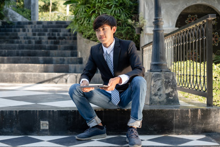 Experienced businessman. picture of a businessman. Asian businessmen sit in front of modern office buildings.の写真素材
