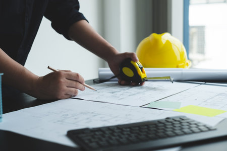 Architects or engineers working construction and drawing construction plans, printing, writing...