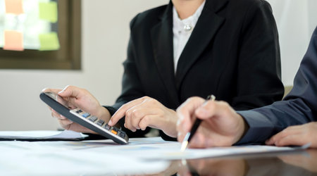 Two business leaders talk about charts, financial graphs showing results are analyzing and calculating planning strategies, business success building processes.の写真素材