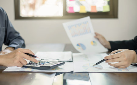 Two business leaders talk about charts, financial graphs showing results are analyzing and calculating planning strategies, business success building processes.の写真素材