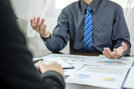 Two business leaders talk about charts, financial graphs showing results are analyzing and calculating planning strategies, business success building processes.の写真素材