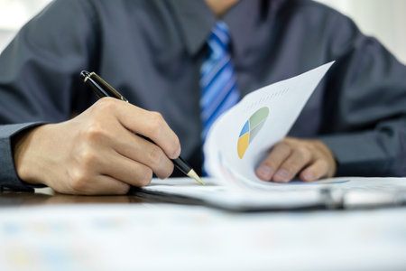 The businessman hand sits at their desks and calculates financial graphs showing the results of their investments planning the process of successful business growth.の写真素材