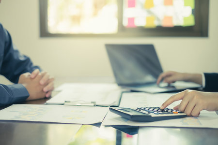 Two business leaders talk about charts, financial graphs showing results are analyzing and calculating planning strategies, business success building processes.の写真素材