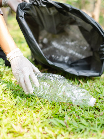 garbage collection, volunteer team pick up plastic bottles, put garbage in black garbage bags to...