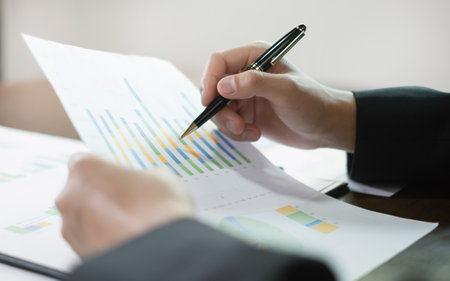 The businessman hand sits at their desks and calculates financial graphs showing the results of their investments planning the process of successful business growth.の写真素材