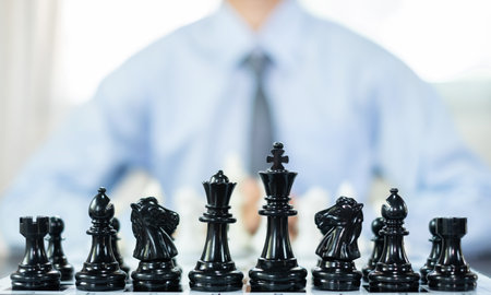 hand of businessmen moving chess in competition shows leadership, followers and business success strategies.の写真素材