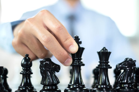 hand of businessmen moving chess in competition shows leadership, followers and business success strategies.の写真素材