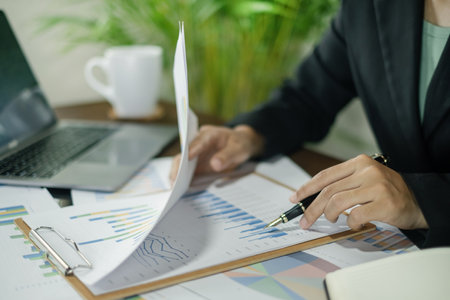The businesswoman hand sits at their desks and calculates financial graphs showing the results of their investments planning the process of successful business growth.の写真素材