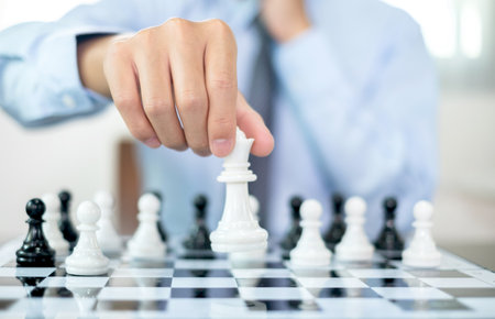 hand of businessmen moving chess in competition shows leadership, followers and business success strategies.の写真素材