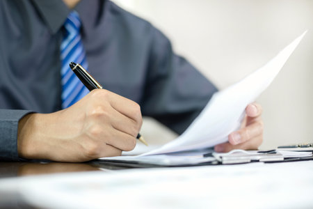 The businessman hand sits at their desks and calculates financial graphs showing the results of their investments planning the process of successful business growth.の写真素材