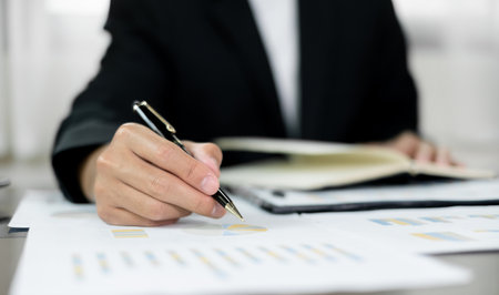 The businessman hand sits at their desks and calculates financial graphs showing the results of their investments planning the process of successful business growth.の写真素材