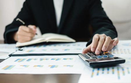 The businessman hand sits at their desks and calculates financial graphs showing the results of their investments planning the process of successful business growth.の写真素材