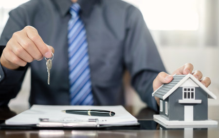 Agents working in real estate investment and home insurance signing contracts in accordance with the home buying insurance agreements approving purchases for clients.の写真素材