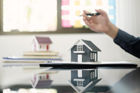 Agents working in real estate investment and home insurance signing contracts in accordance with the home buying insurance agreements approving purchases for clients.の写真素材