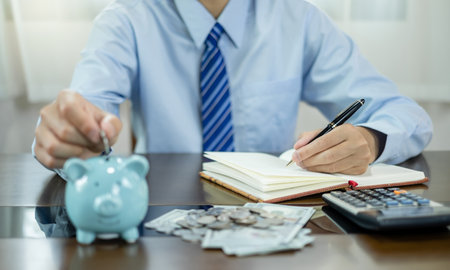 Hand putting coin into piggy bank. Saving money with coins Step into a business that is growing to be successful and save for retirement concepts.の写真素材
