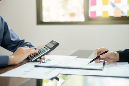 Two business leaders talk about charts, financial graphs showing results are analyzing and calculating planning strategies, business success building processes.の写真素材