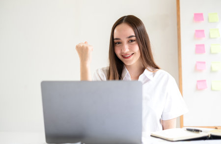 Video call. Young Asian woman communicating on long-distance online video. looking digital laptop screen Happy talking with friends happily.の写真素材