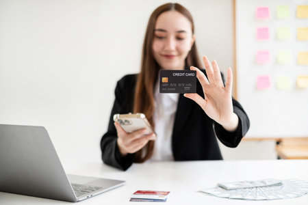 Asian girl shopping online holding credit and using smartphone enter their card number in the mobile phone app to purchase and payment in internet store.の写真素材