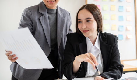 Two business leaders talk about charts, financial graphs showing results are analyzing and calculating planning strategies, business success building processes.の写真素材