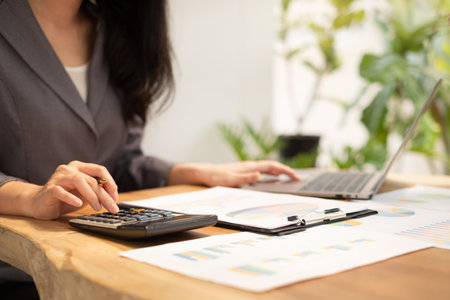 Asian businesswomen calculate financial graphs showing results about their investments and planning successful business growth process in the office.の写真素材