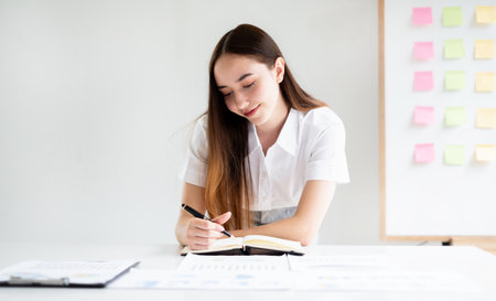 Asian businesswoman calculate financial graphs showing results about their investments and planning successful business growth process in the office.の写真素材