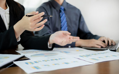 Two business leaders talk about charts, financial graphs showing results are analyzing and calculating planning strategies, business success building processes.の写真素材