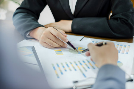 Two business leaders talk about charts, financial graphs showing results are analyzing and...