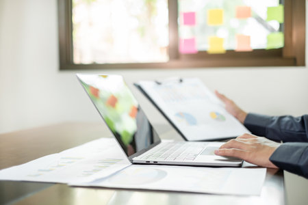 The business hand sits at their desks and calculates financial graphs showing the results of their...