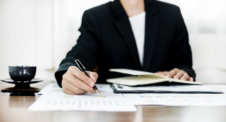 The business hand sits at their desks and calculates financial graphs showing the results of their investments planning the process of successful business growth.の写真素材