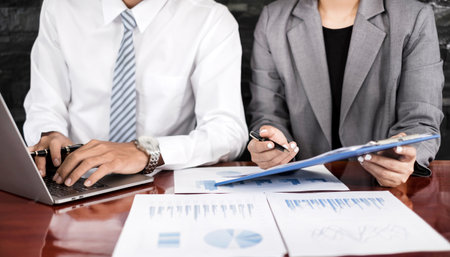 Two business leaders talk about charts, financial graphs showing results are analyzing and calculating planning strategies, business success building processes.の写真素材