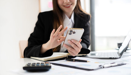 Asian businesswoman calculate financial graphs showing results about their investments and planning successful business growth processes in the office.の写真素材