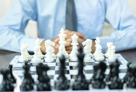 hand of businessmen moving chess in competition shows leadership, followers and business success strategies.の写真素材