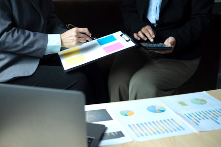 Two business leaders talk about charts, financial graphs showing results are analyzing and calculating planning strategies, business success building processes.の写真素材