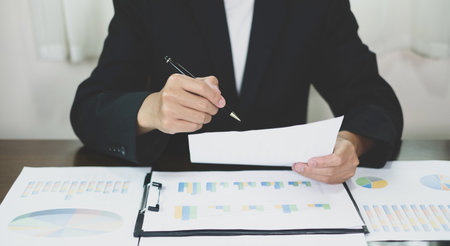 The businessman hand sits at their desks and calculates financial graphs showing the results of their investments planning the process of successful business growth.の写真素材