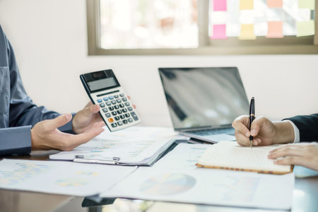Two business leaders talk about charts, financial graphs showing results are analyzing and calculating planning strategies, business success building processes.の写真素材