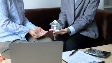 The real estate agent gives the house to a new owner's client after completing the signing of the lease and formally completing home insurance. Rental and insurance concepts.の写真素材
