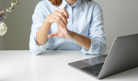 Woman hand with wrist pain numbness and pain in the palm of the hand has pain and tingling in the nerve endings This is a side effect of sitting and working for a long time on a laptop at the office.の写真素材