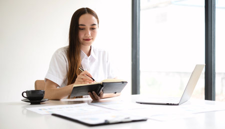 Asian businesswoman calculate financial graphs showing results about their investments, plan a successful business growth process.の写真素材