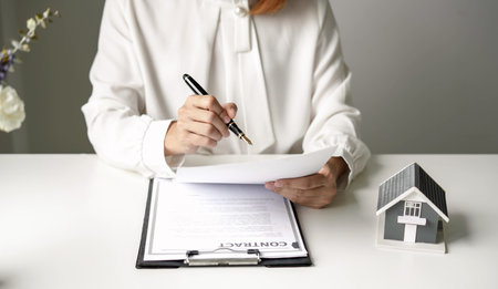 agents working in real estate investment and home insurance signing contracts in accordance with the home buying insurance agreements approving purchases for clients.の写真素材