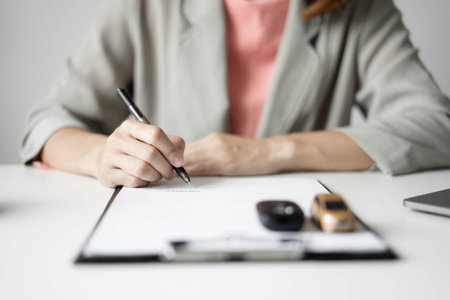 Car dealer businesswoman signing car insurance document or lease paper. Car insurance, loans and Car...