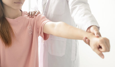 Female physiotherapists provide physical assistance to patients with shoulder injuries massaging...