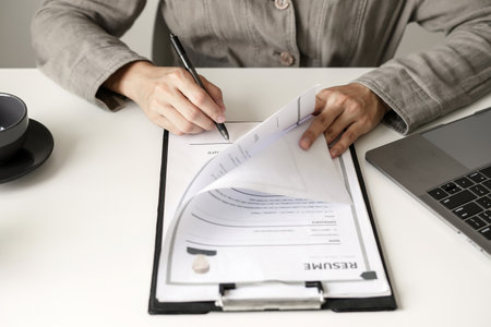 Business woman employer holding resume hiring recruit looking cv resume to hire candidates, analyzing information before job interview. Recruitment concepts.の写真素材