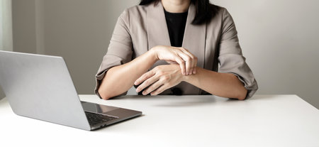 Woman hand with wrist pain numbness and pain in the palm of the hand has pain and tingling in the nerve endings This is a side effect of sitting and working for a long time on a laptop at the office.の写真素材